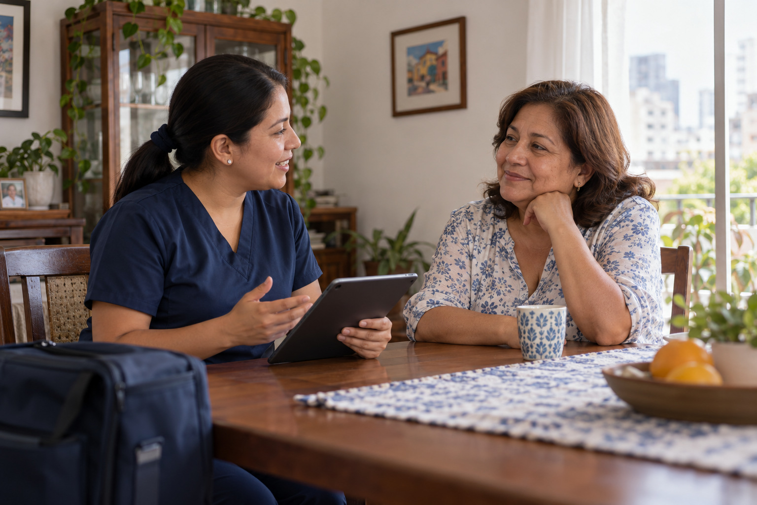 Profesional de Cleom Salud conversando con una paciente en su comedor